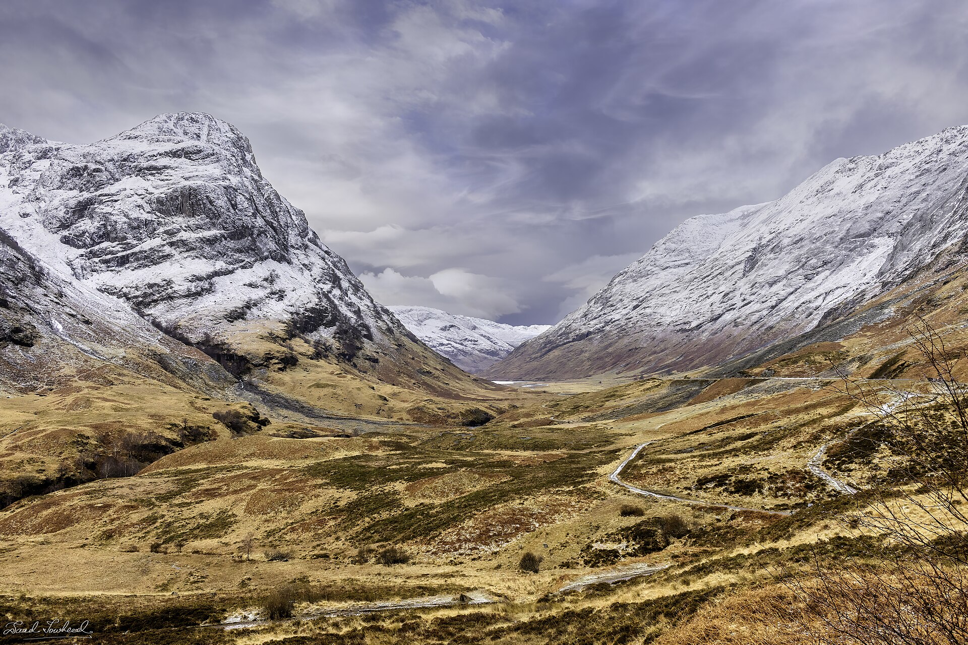 Snow-dusted mountains rising over a highland glen